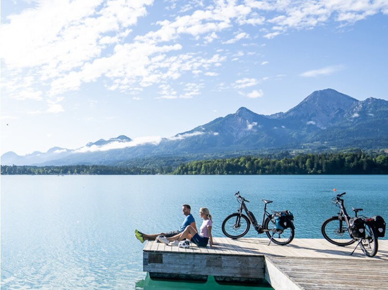 Na bicykli po Rakúsku - Cyklotrasa pri jazerách Rakusko, Faaker See dvaja cyklisti a jazero
