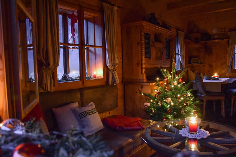 interér chaty s vianočným stromčekom a sviečkami