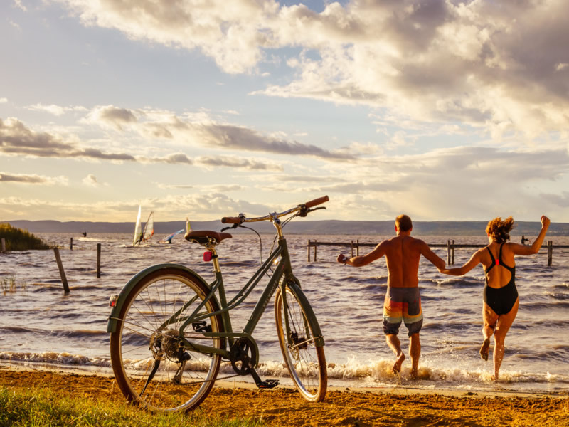 Rakusko, Neusiedlersee, dvaja cyklisti skacu do jazera