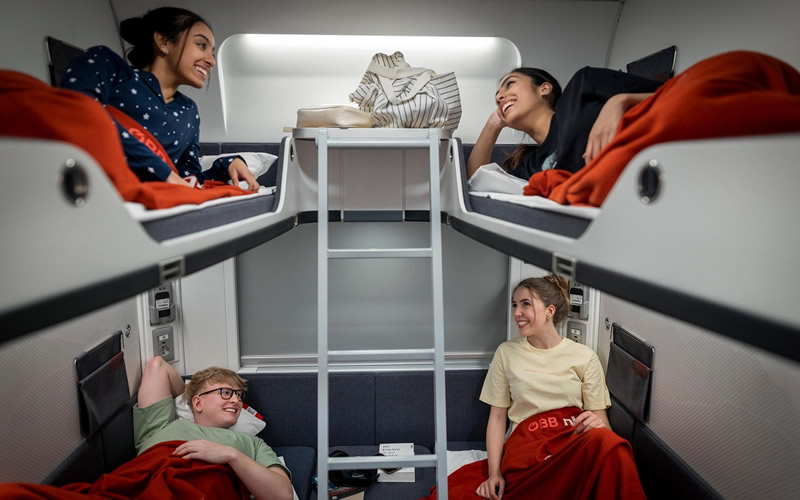 styria mladi ludia v kupe - kazdy lezi na svojej poschodovej posteli vo vlaku