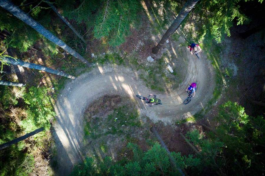pohlad zhora na cyklistov v strmom lesnom stupani