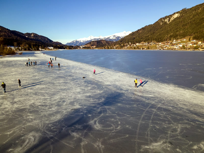 Rakusko, zamrznuté jazero Weissensee, korčuliari