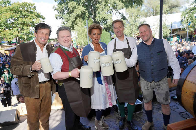 Podium, moderatori a politici si pripijaju velkymi krcahmi piva na Oktoberfest e, Vieden, Prater