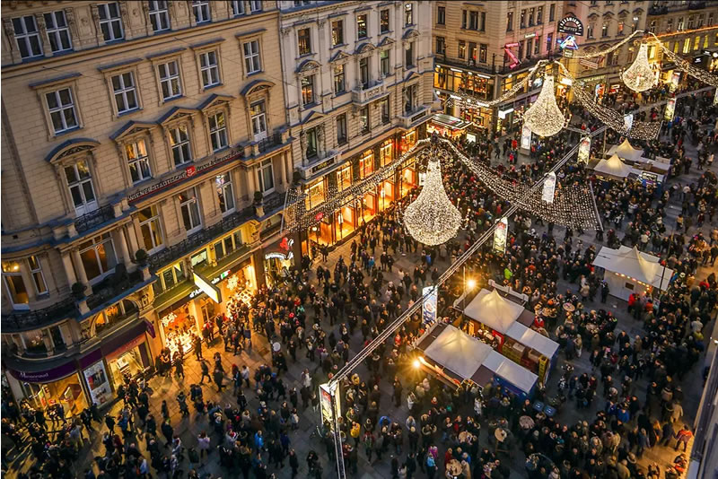 pohľad zhora na ulicu Viedne, vyzdobenú svetlami, ľudia vítajú nový rok
